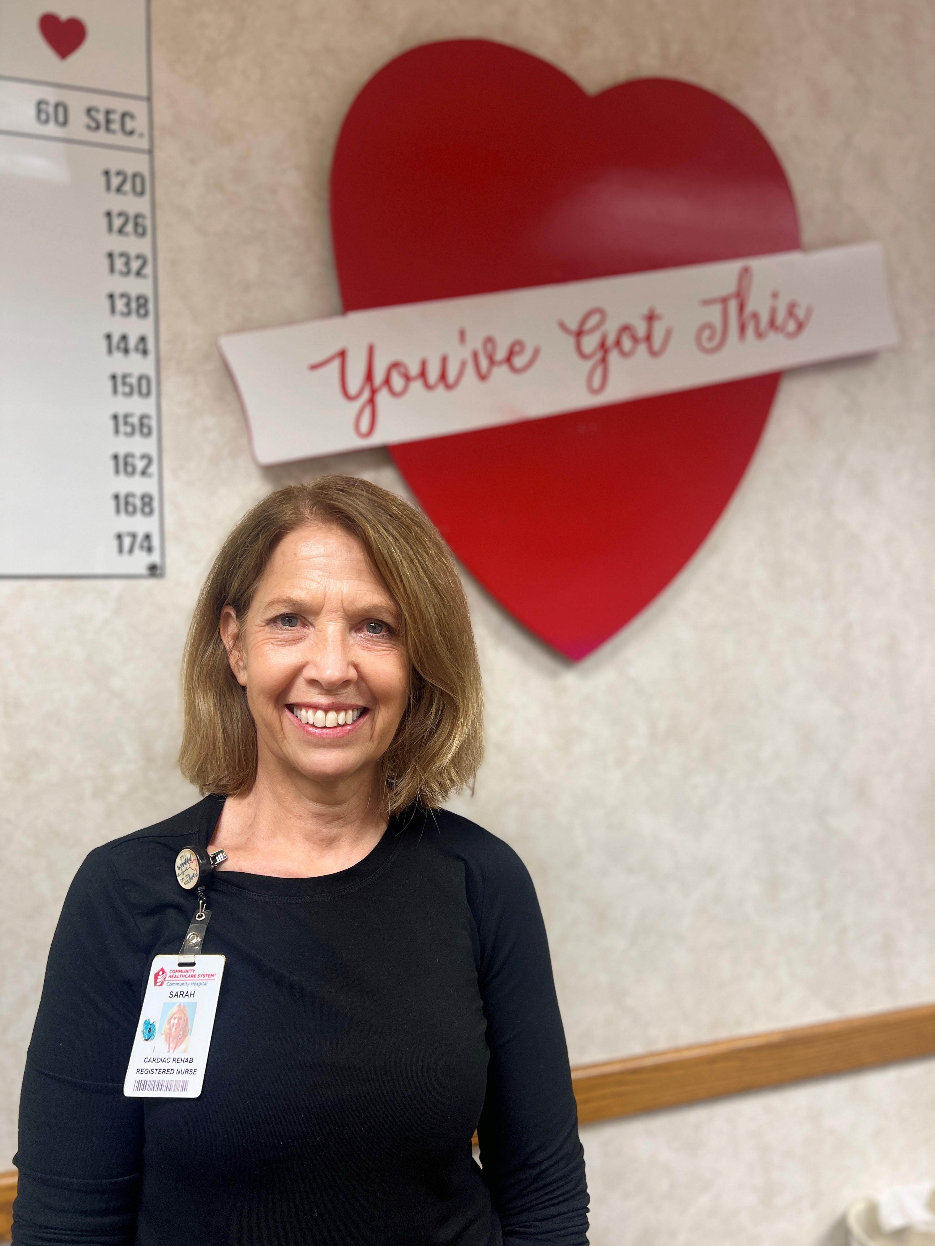 Sarah Colias Standing in front of a heart poster